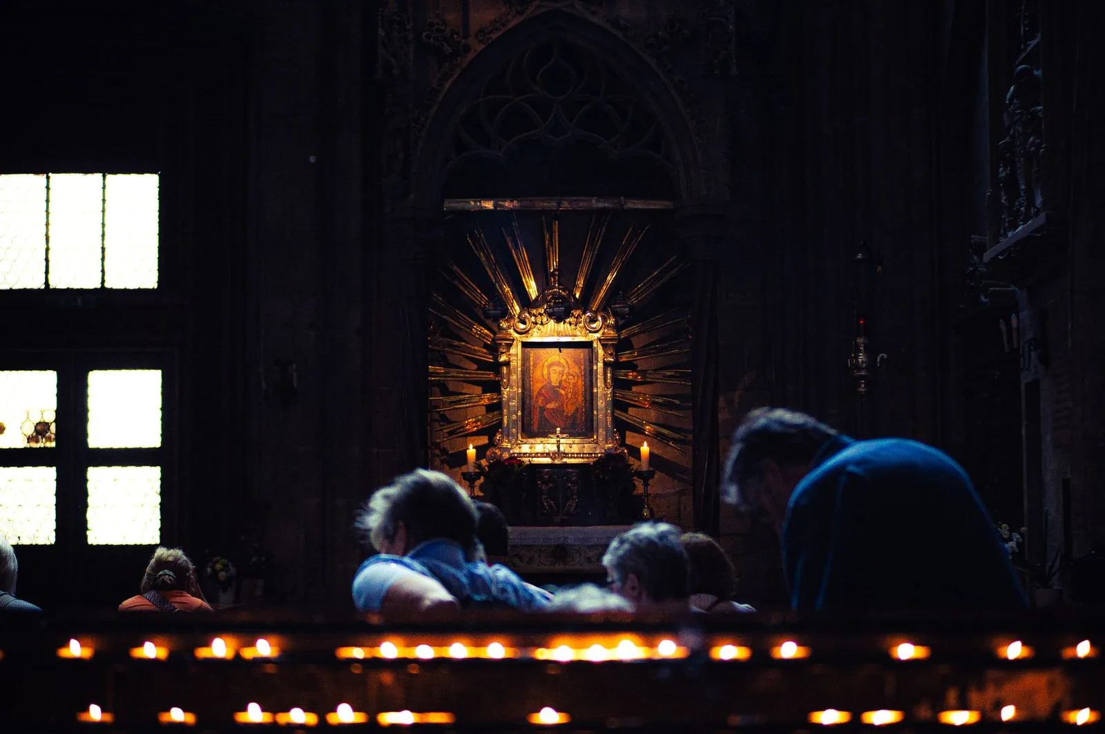 Candles and worshippers inside St. Stephen's Cathedral in Vienna at night