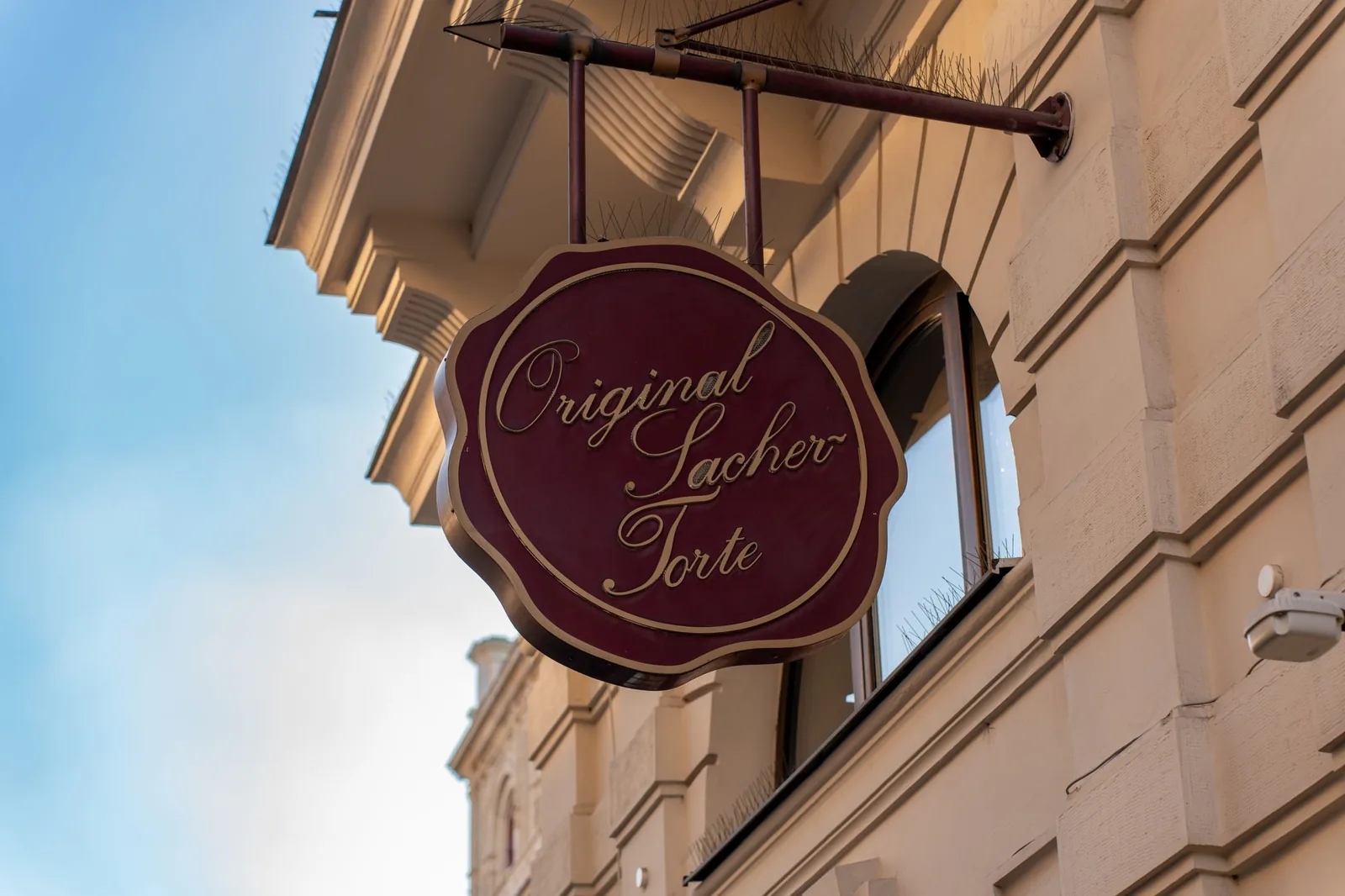 Ornate Original Sacher-Torte sign on a Vienna building facade