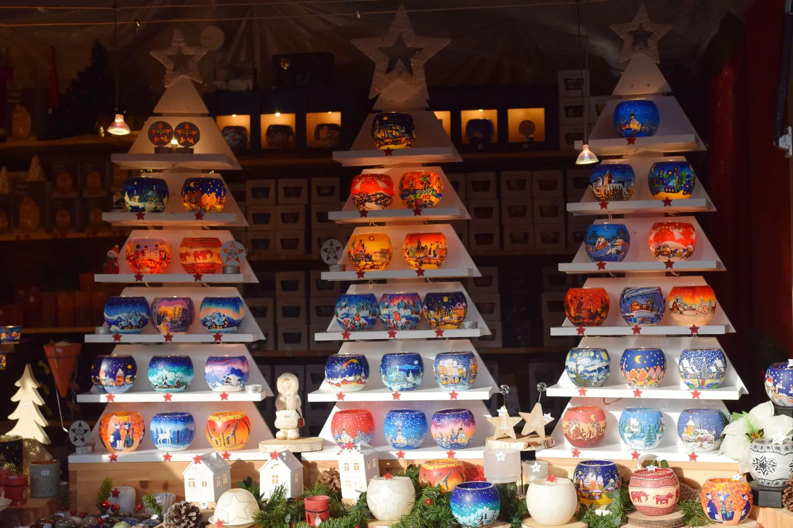 Rows of glowing painted candle holders on a Strasbourg Christmas market stall