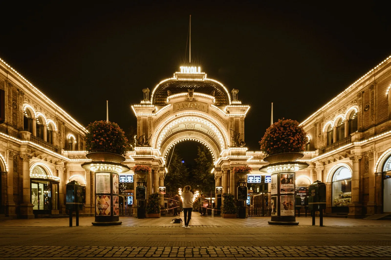 The ornate main entrance of Tivoli Gardens in Copenhagen lit up at night