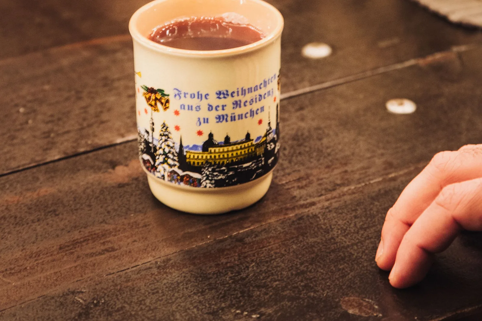 Steaming mug of Glühwein mulled wine on a wooden counter at a German Christmas market