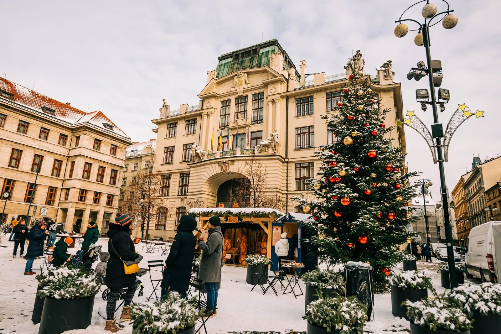 Tall Christmas tree and market huts among pastel buildings in Prague Old Town